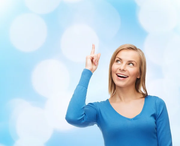 Mujer sonriente señalando con el dedo hacia arriba — Foto de Stock