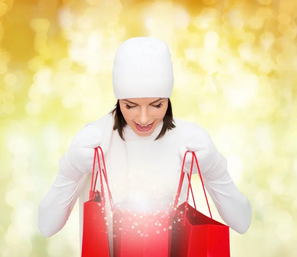 Jeune femme souriante avec des sacs à provisions rouges — Photo