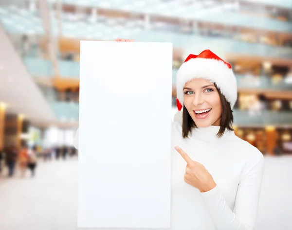 Sorridente giovane donna in cappello di Babbo Natale con tavola bianca — Foto Stock