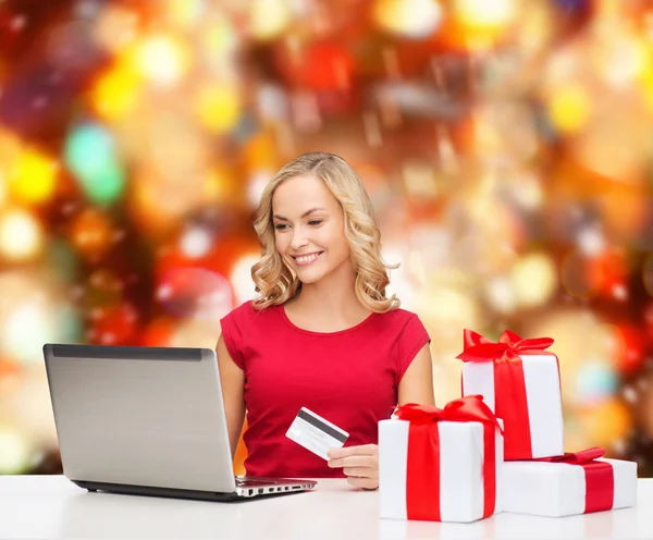 Smiling woman with credit card and laptop — Stock Photo, Image