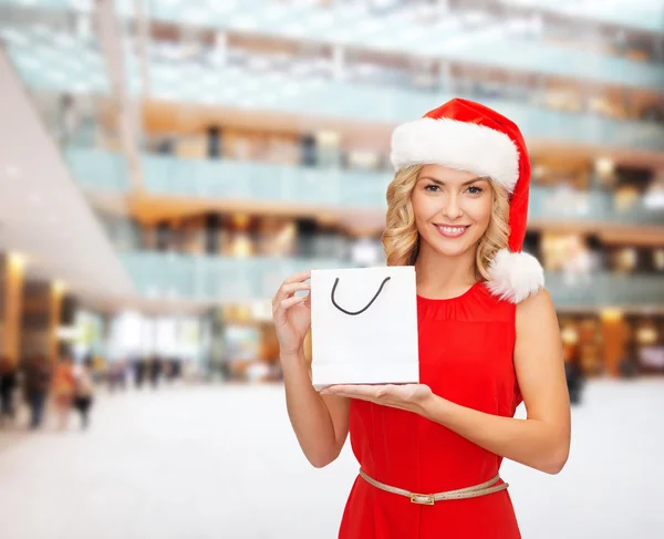 Frau mit Weihnachtsmann-Helfermütze mit Einkaufstaschen — Stockfoto