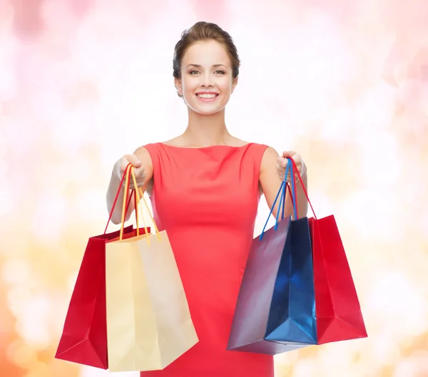 Femme élégante souriante en robe avec des sacs à provisions — Photo