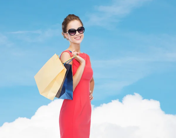 Lächelnde elegante Frau im Kleid mit Einkaufstaschen — Stockfoto