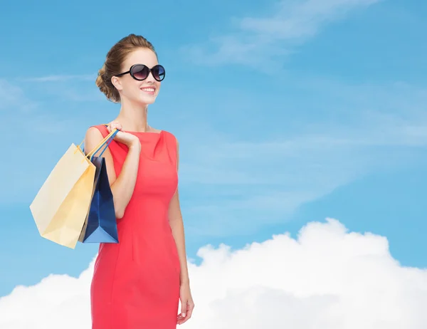 Mujer elegante sonriente en vestido con bolsas de compras — Foto de Stock