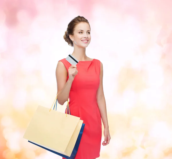 Leende kvinna med shoppingväskor och plastkort — Stockfoto