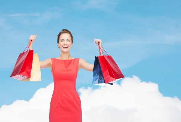 Riendo mujer elegante en vestido con bolsas de compras — Foto de Stock