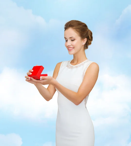 Sorrindo mulher segurando caixa de presente vermelho — Fotografia de Stock