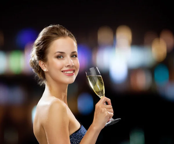 Sonriente mujer sosteniendo un vaso de vino espumoso — Foto de Stock