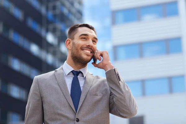 Hombre de negocios sonriente con teléfono inteligente al aire libre — Foto de Stock