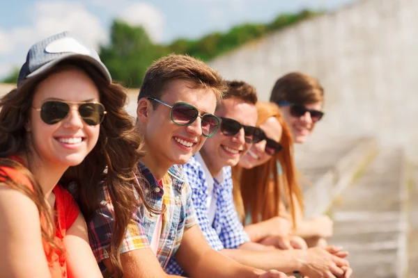 Close up of smiling friends sitting on city street — Stock Photo, Image