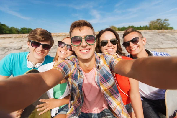 Grupp leende vänner att göra selfie utomhus — Stockfoto