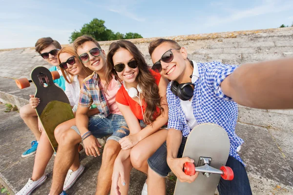 Grupa przyjaciół uśmiechający się z smartphone na zewnątrz — Zdjęcie stockowe