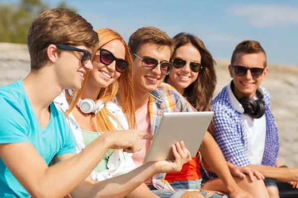 Grupo de amigos sonrientes con tableta PC al aire libre — Foto de Stock