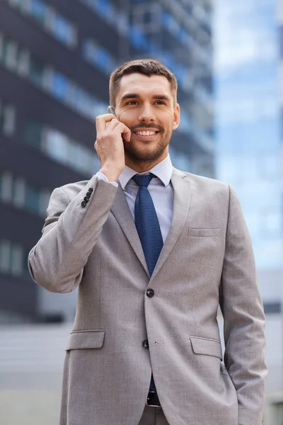 Smiling businessman with smartphone outdoors Stock Image