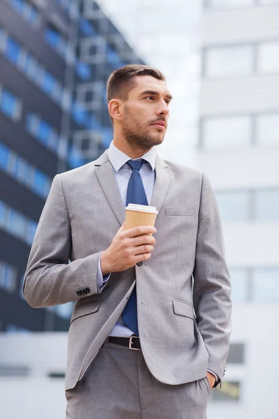 Giovane uomo d'affari serio con tazza di carta all'aperto — Foto Stock