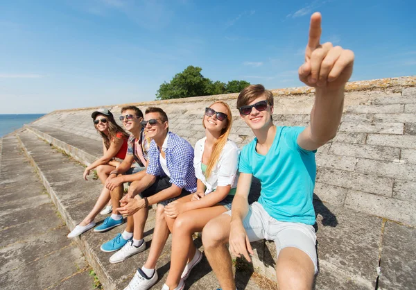 Skupina usmívající se přátel, sedí na ulici města — Stock fotografie