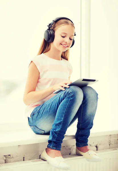 Ragazza con tablet pc e cuffie a casa — Foto Stock