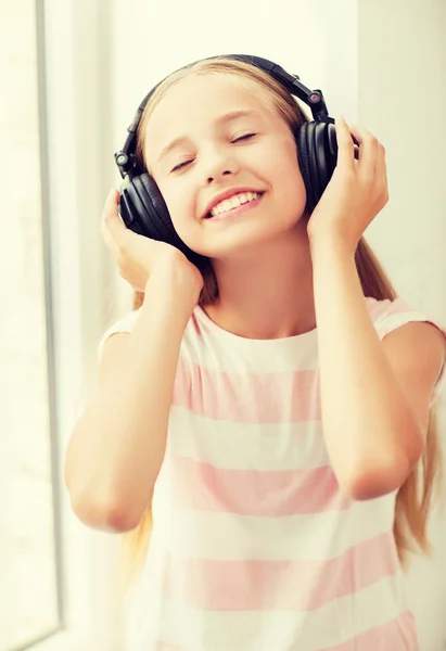 Niña con auriculares en casa — Foto de Stock