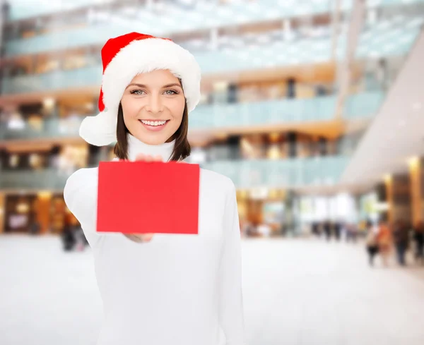 Mujer en sombrero de ayudante de santa con tarjeta roja en blanco —  Fotos de Stock