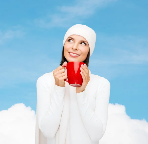 Sonriente mujer joven en ropa de invierno con taza — Foto de Stock