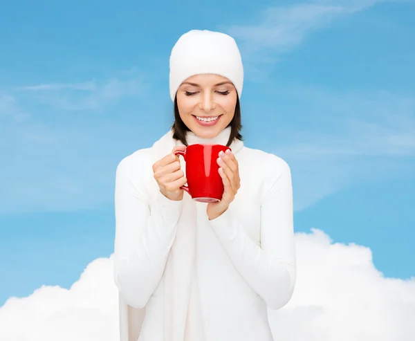 Sonriente mujer joven en ropa de invierno con taza — Foto de Stock