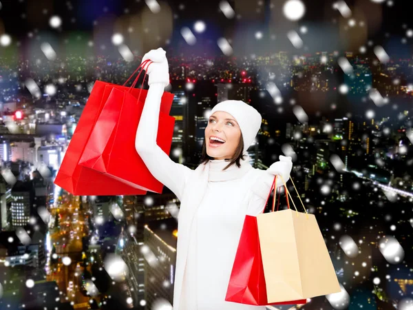 Smiling young woman with red shopping bags — Stock Photo, Image