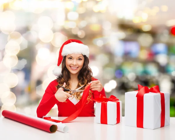 Sorrindo mulher em santa helper chapéu embalagem caixa de presente — Fotografia de Stock