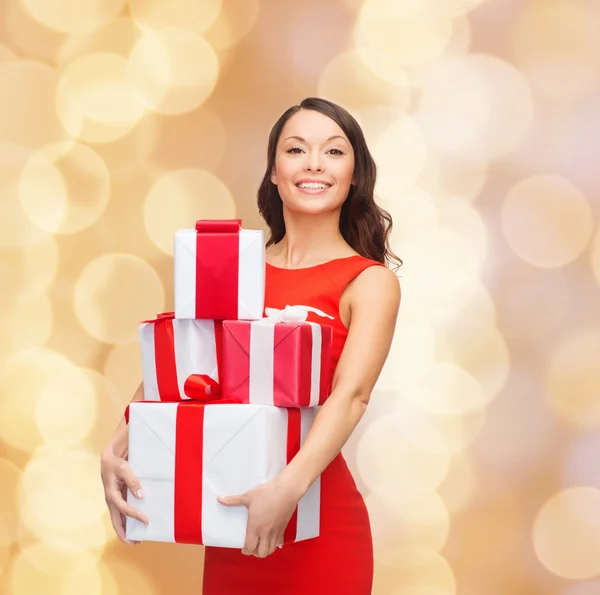 Lachende vrouw in rode jurk met doos van de gift — Stockfoto