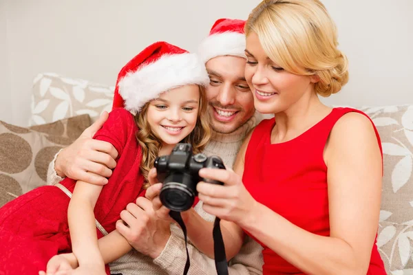 在圣诞老人的助手帽子看着到画面中的家庭 — 图库照片