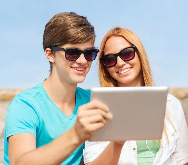 Grupa przyjaciół uśmiechający się z komputera typu tablet na zewnątrz — Zdjęcie stockowe