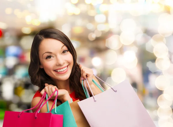 Lachende jonge vrouw met shopping tassen — Stockfoto