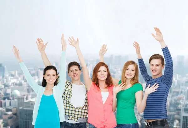 Group of smiling students waving hands — Stock Photo, Image