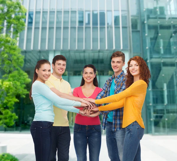 Lachende tieners met handen bovenop elkaar — Stockfoto