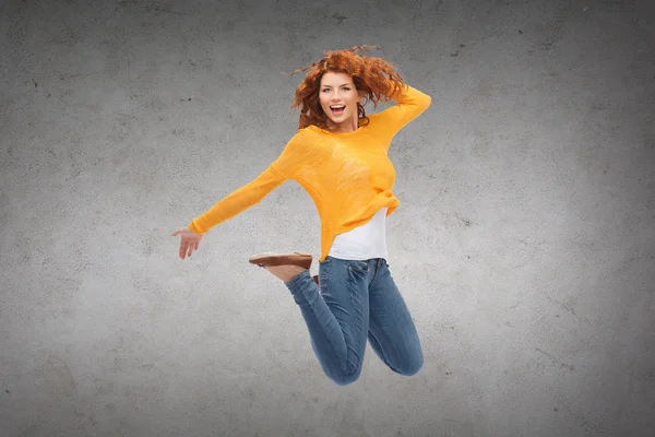 Lachende jonge vrouw springen in de lucht — Stockfoto