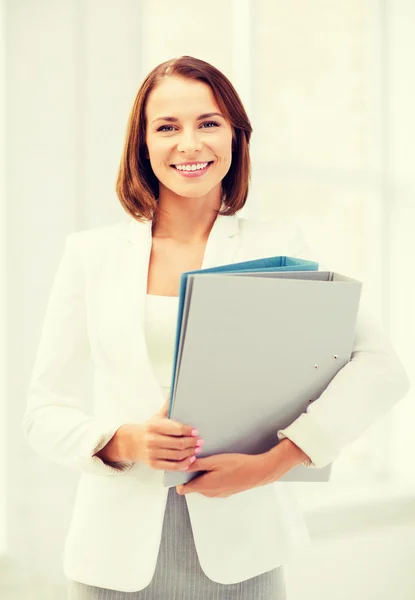 Zakenvrouw met mappen in office — Stockfoto