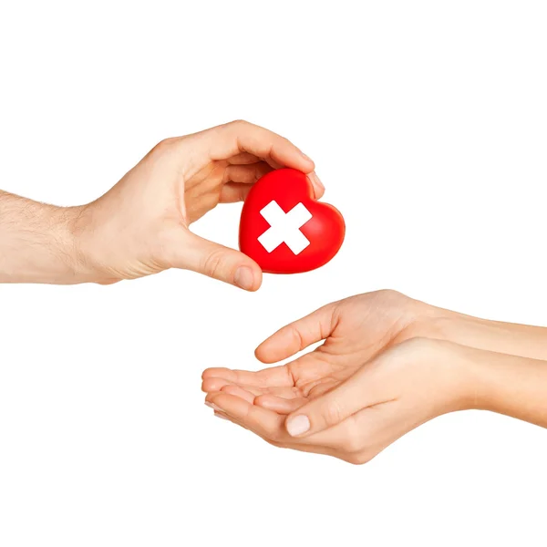 Mão dando coração com símbolo de cruz vermelho — Fotografia de Stock