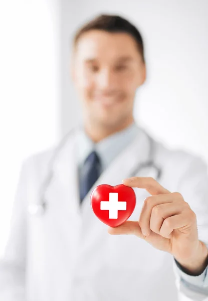 Médico varón sosteniendo el corazón con el símbolo de la cruz roja —  Fotos de Stock