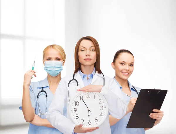 Calmo medico femminile e infermiere con orologio da parete — Foto Stock