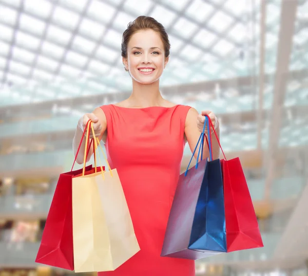 Uśmiechający się elegancka kobieta w sukni z torby na zakupy — Zdjęcie stockowe