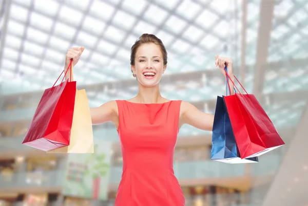 Lachen elegante vrouw in jurk met shopping tassen — Stockfoto