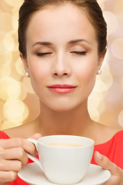 Femme souriante en robe rouge avec tasse de café — Photo