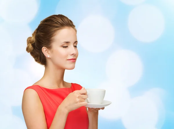 Mujer sonriente en vestido rojo con taza de café — Foto de Stock