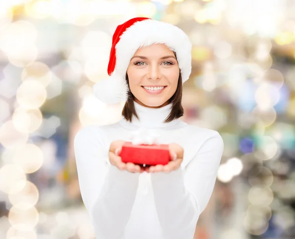 Donna sorridente in cappello Babbo Natale helper con confezione regalo — Foto Stock