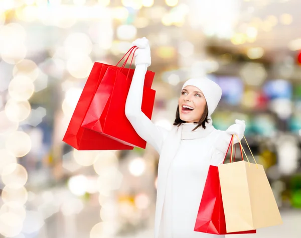 Giovane donna sorridente con borse della spesa rosse — Foto Stock