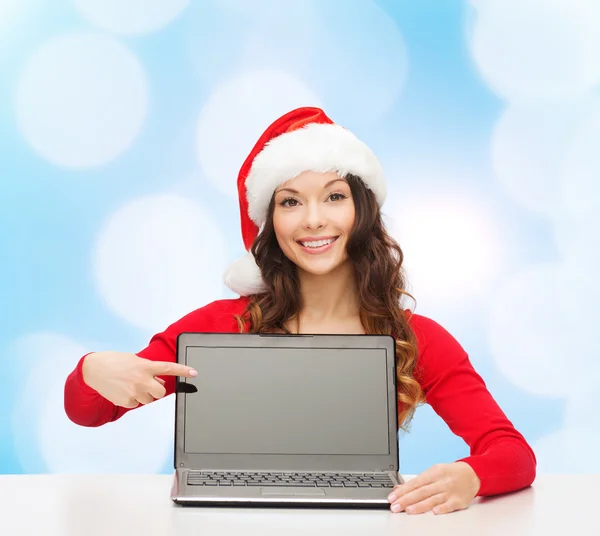 Lachende vrouw in helper kerstmuts met laptop — Stockfoto