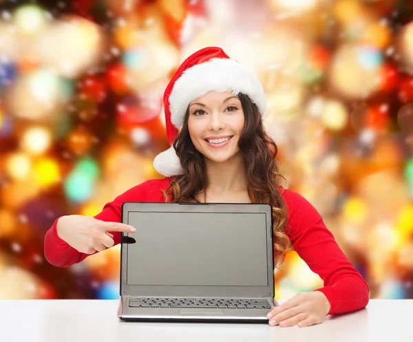 Lächelnde Frau mit Weihnachtsmannmütze und Laptop — Stockfoto