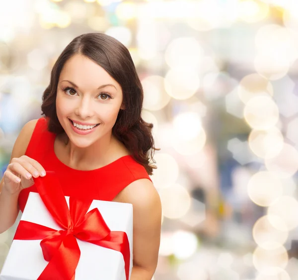 Lachende vrouw in rode jurk met doos van de gift — Stockfoto