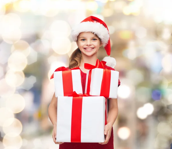 Sorrindo menina em santa chapéu ajudante com presentes — Fotografia de Stock