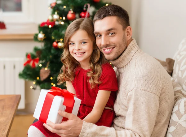 Leende far och dotter håller presentförpackning — Stockfoto