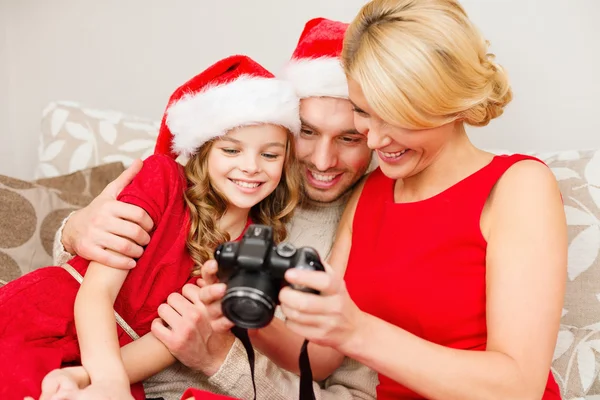 Семья в шляпах-помощниках Санта-Клауса смотрит на картины — стоковое фото